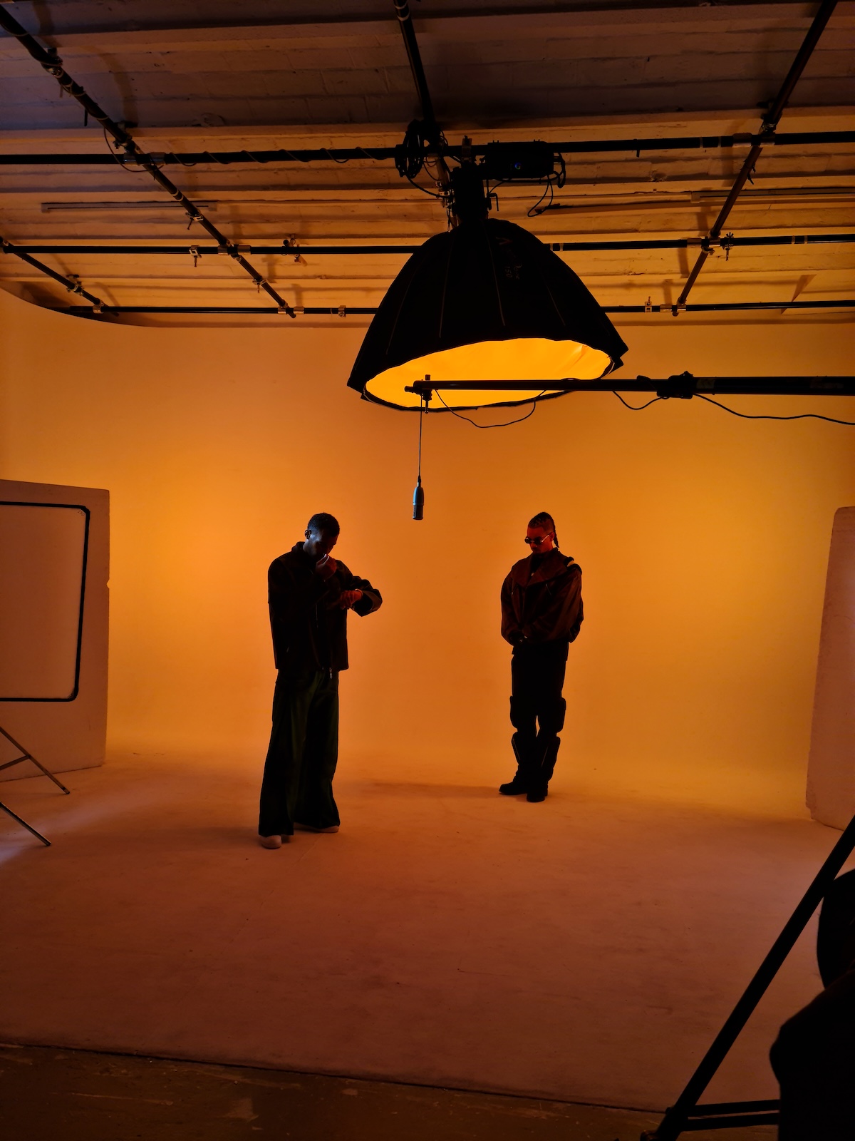 Lyris Haye — direction artistique en studio sous lumière orange avec artistes en silhouette