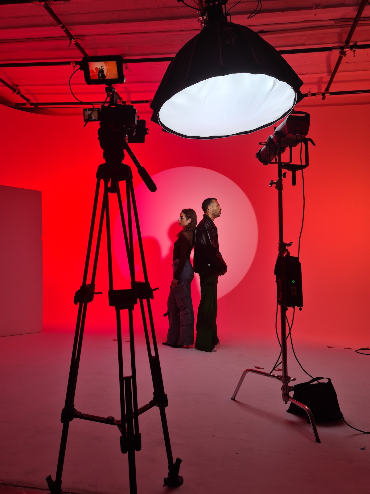 Lyris Haye — tournage en studio sous éclairage rouge avec artistes et équipement cinéma